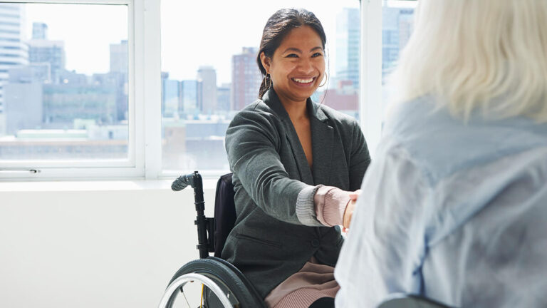 Hiring manager in a wheelchair rehiring an employee.