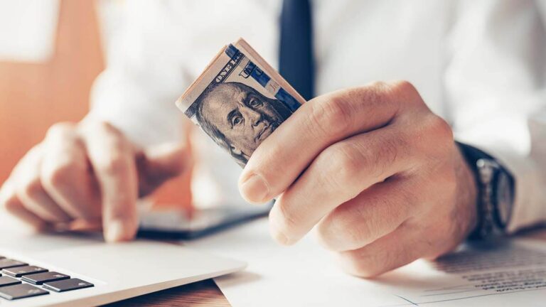Business owner holding $100 bills.