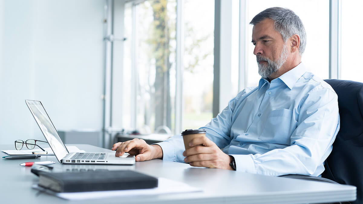 Older man working on a laptop.