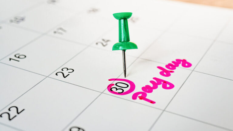 Pay day marked with a pin on a calendar.