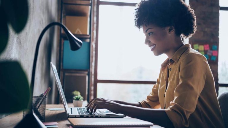 Side profile of a woman on a computer.