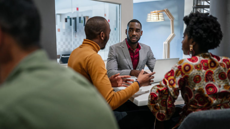 Team of executives sitting at a table and talking.