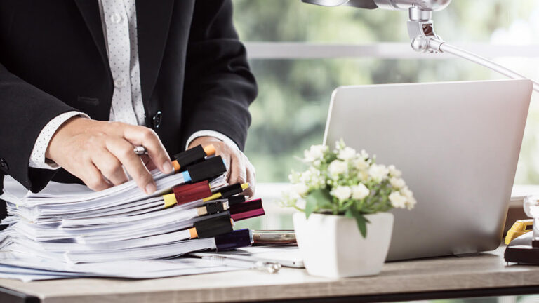 Business professional with a stack of papers.