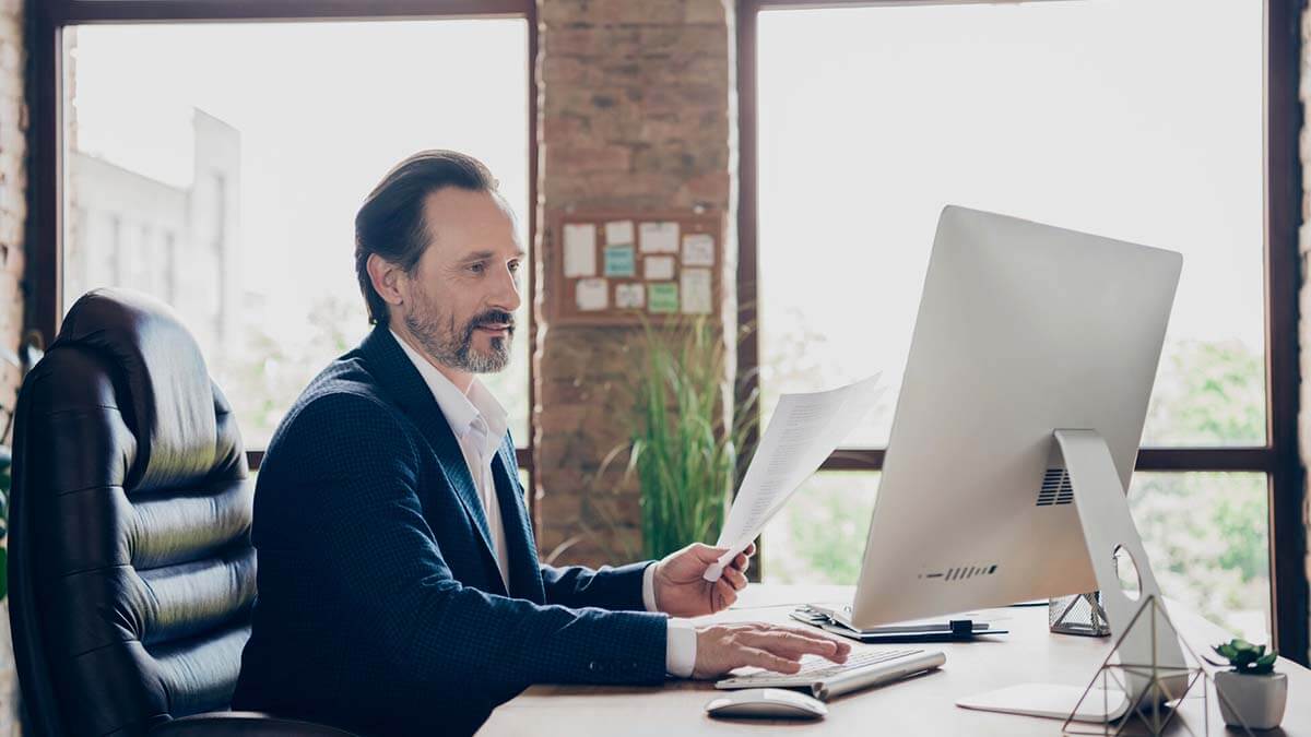Man in a brick office using a computer.