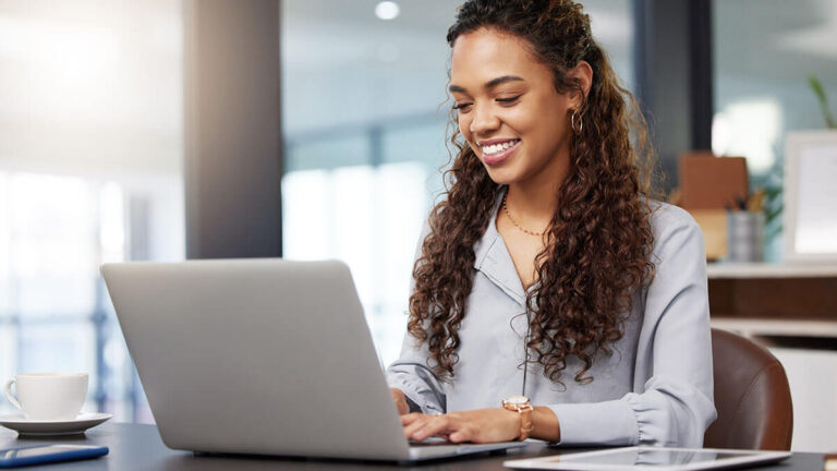 Woman smiling at the laptop.