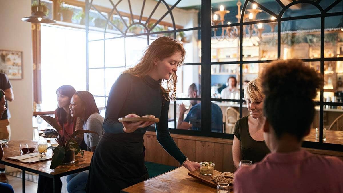 Tipped employee picking up dishes.