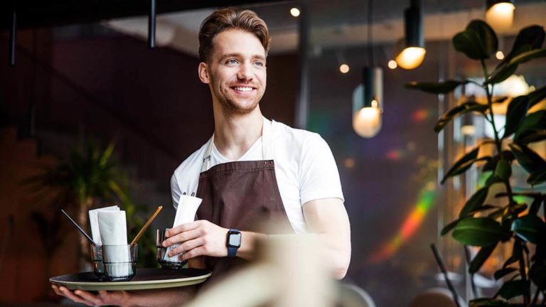 Barista smiling to someone off camera.