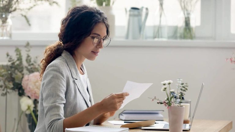Self-employed woman holding a slip of paper.