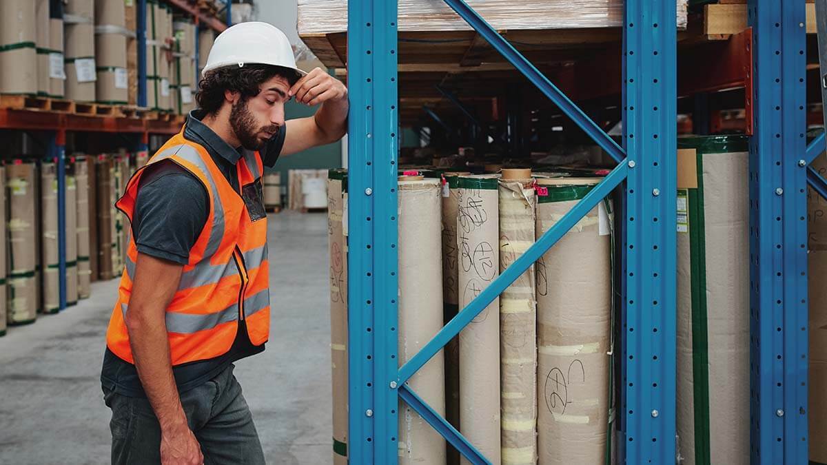 Construction worker leaning against shelf.
