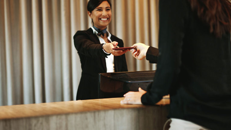 Flight attendant handing passport to traveler.