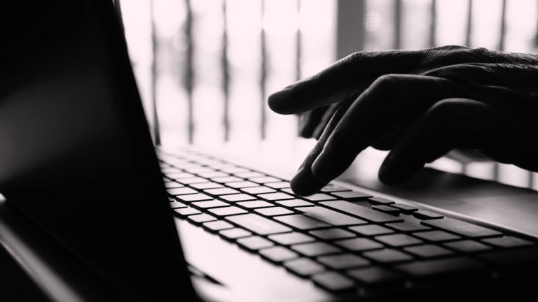 Black and white photo of hands on a keyboard.