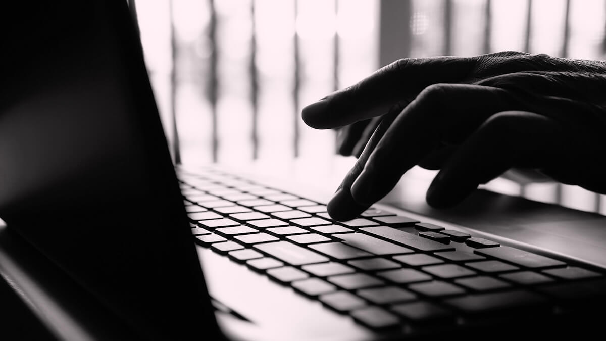 Black and white photo of hands on a keyboard.