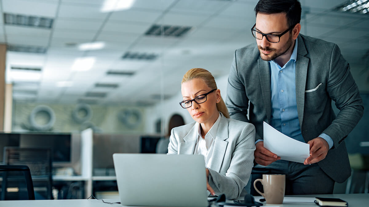 Two business professionals reviewing fixed costs.