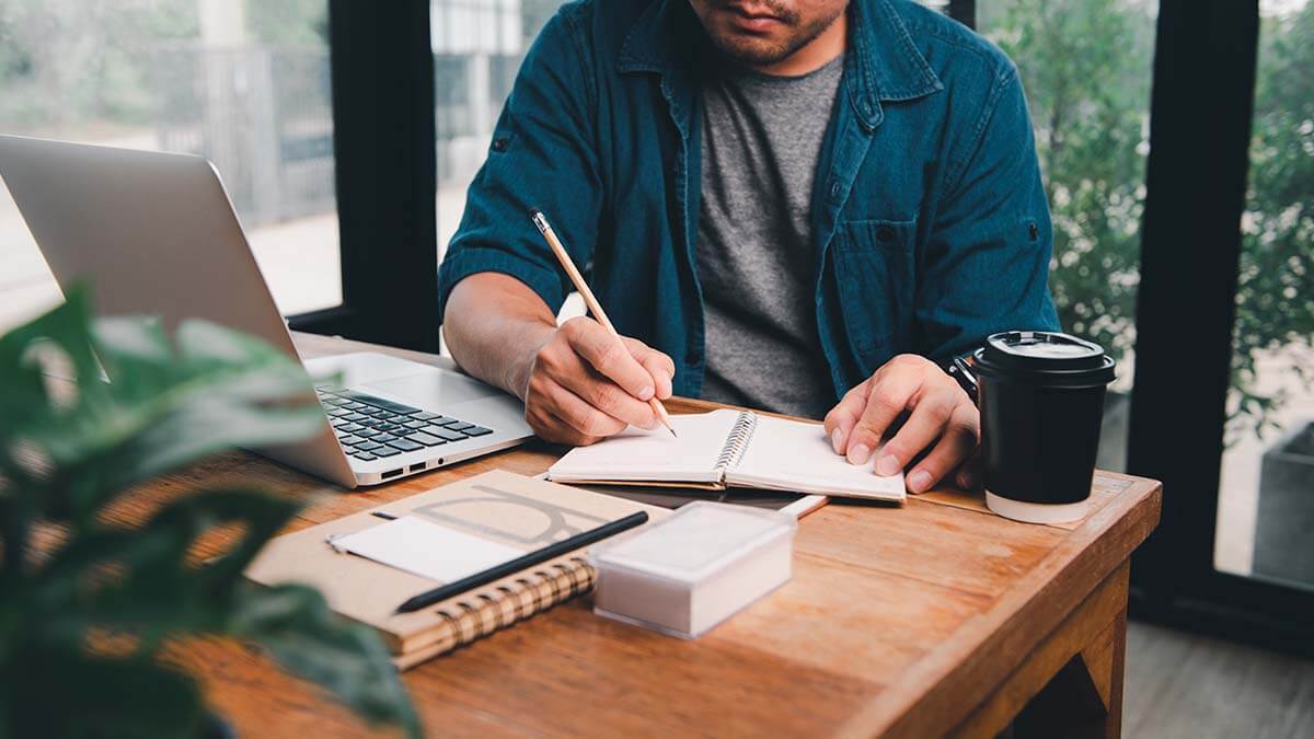 Man writing in a notebook.