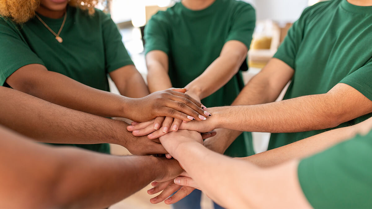 Team of nonprofit workers with their hands in a huddle.