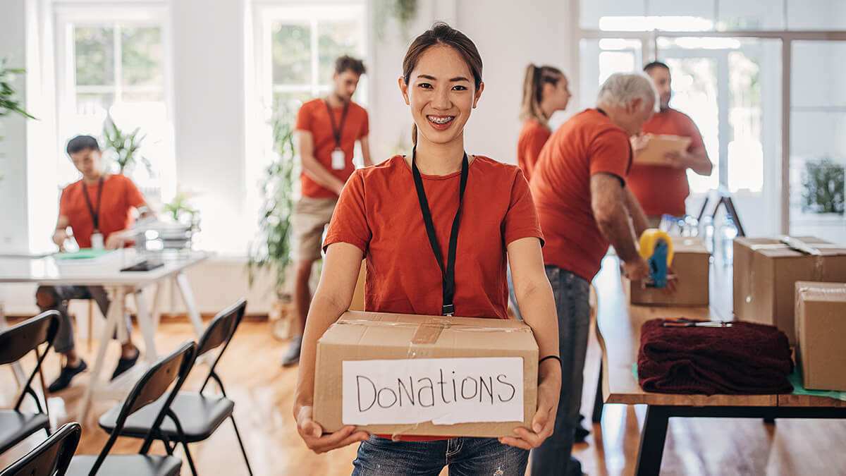 Smiling nonprofit volunteer with team behind her.