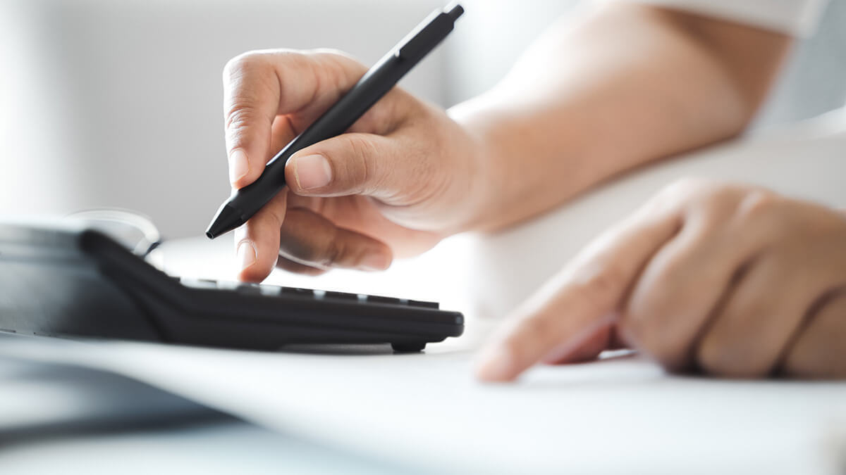 Person using a calculator with a pen.