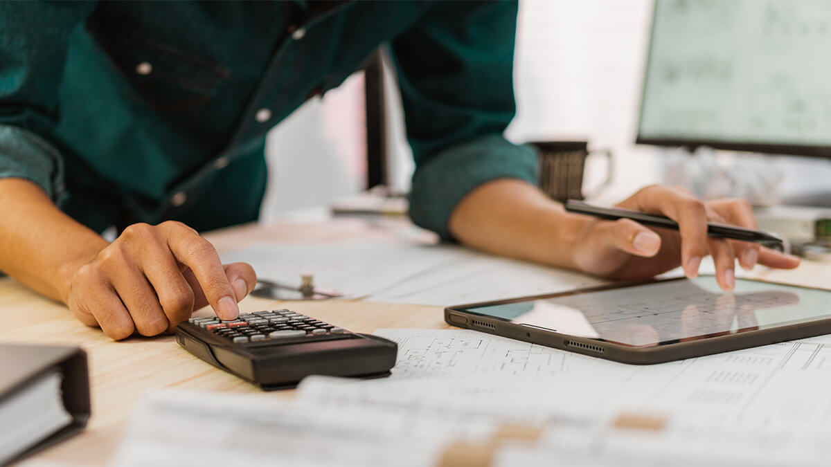 Business owner using a tablet and calculator.