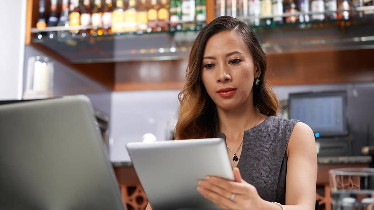 Woman using cash-based accounting on tablet.