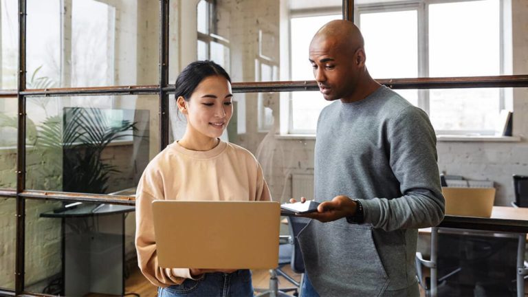 Man and woman talking about something on a laptop.