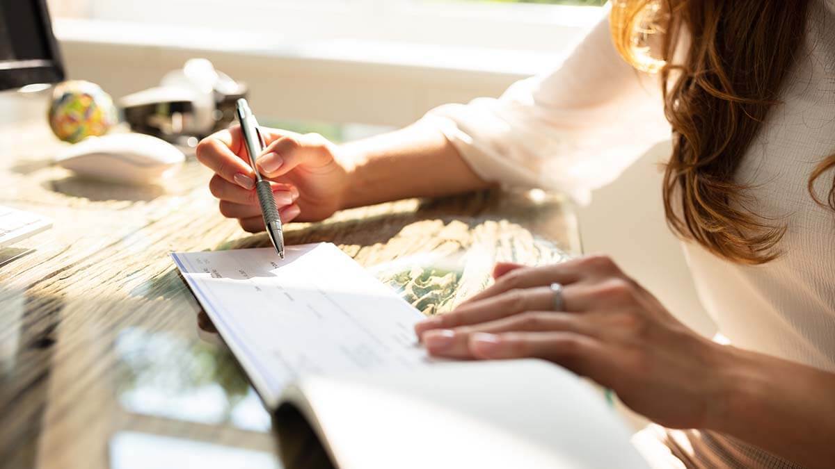 Employer writing a paycheck after running payroll.