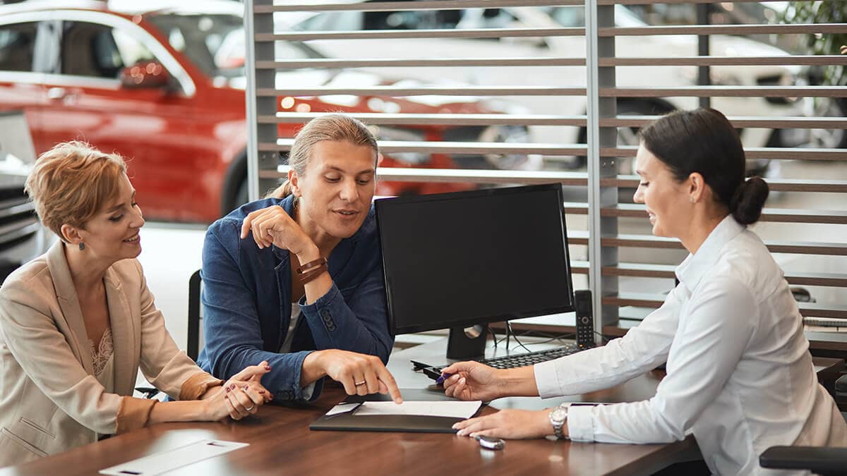 Car dealer working with customers.