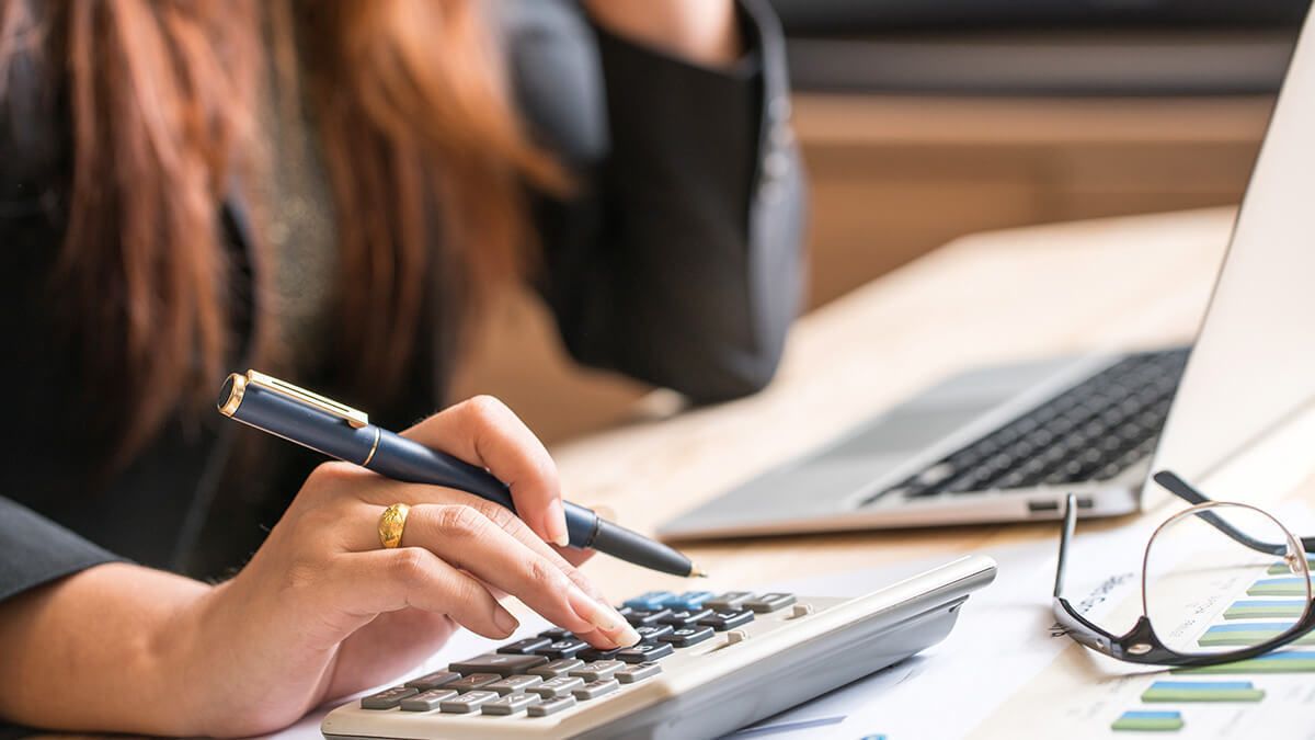Business owner calculating severance pay on calculator.