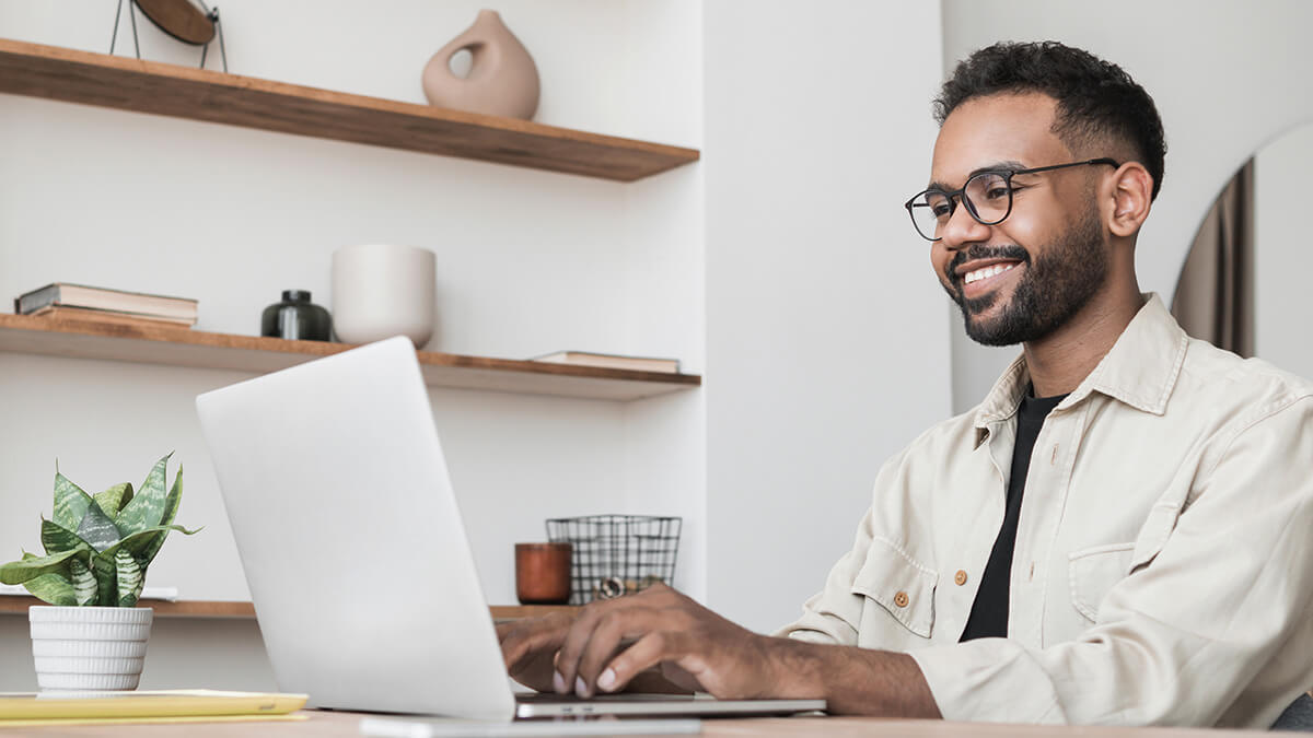 Man smiling at computer.