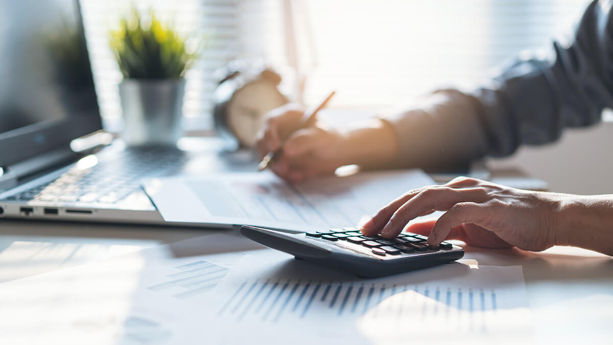 Employer using a calculator to calculate unemployment tax.