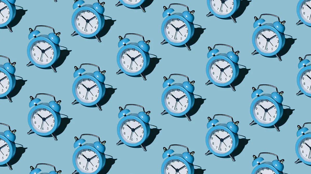 Rows of blue alarm clocks on a blue background